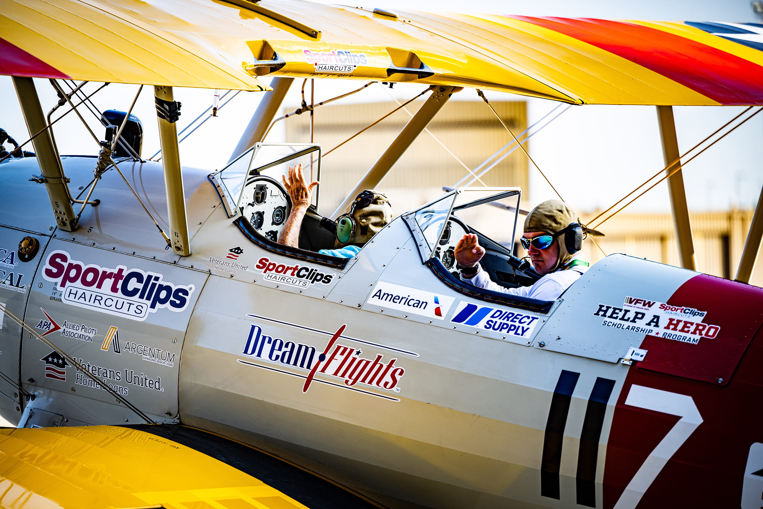 an elderly man and a younger man in a WWII-era plane