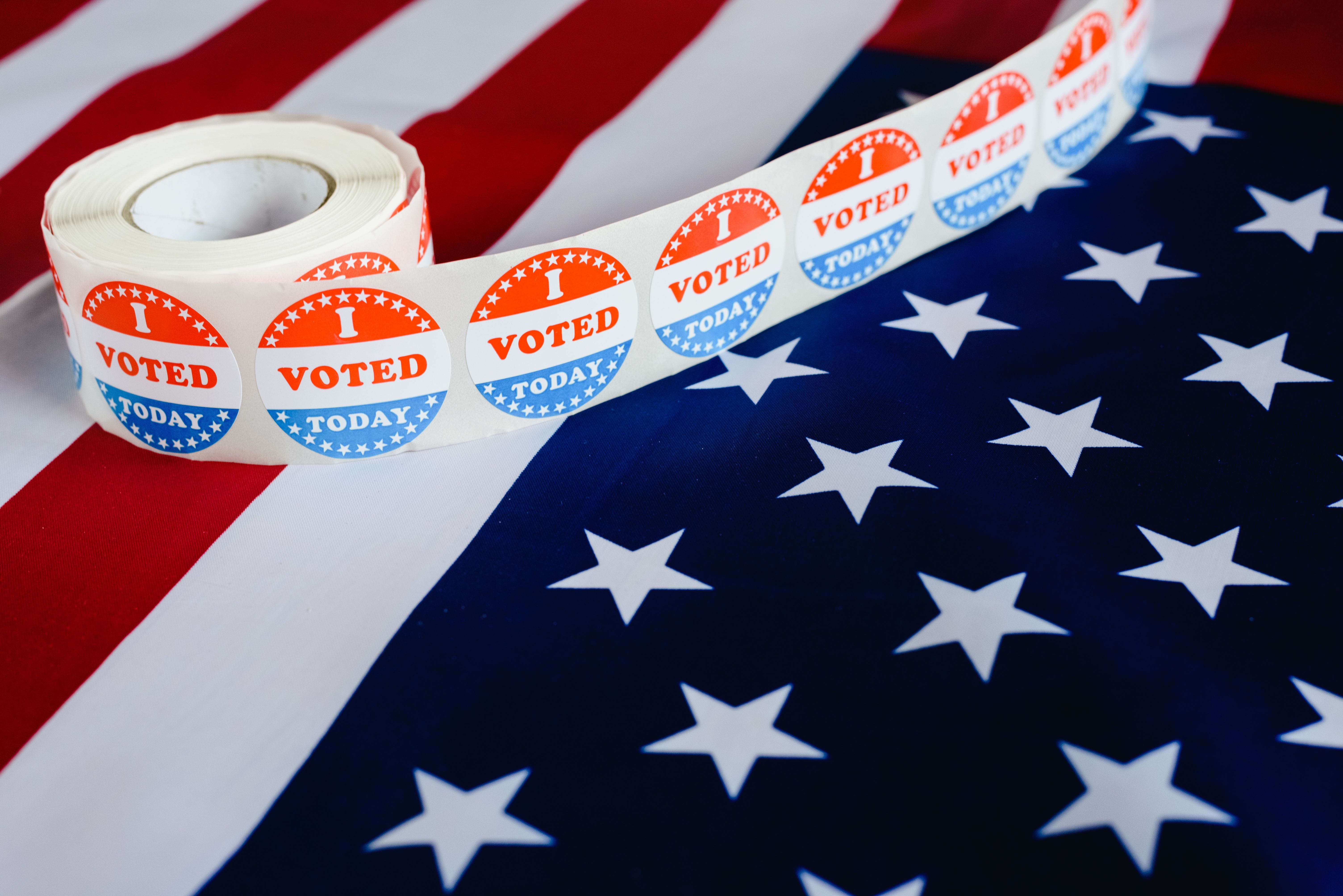 a roll of I Voted Today stickers on an American flag