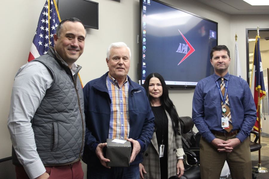 four pilots, one of whom is holding a trophy