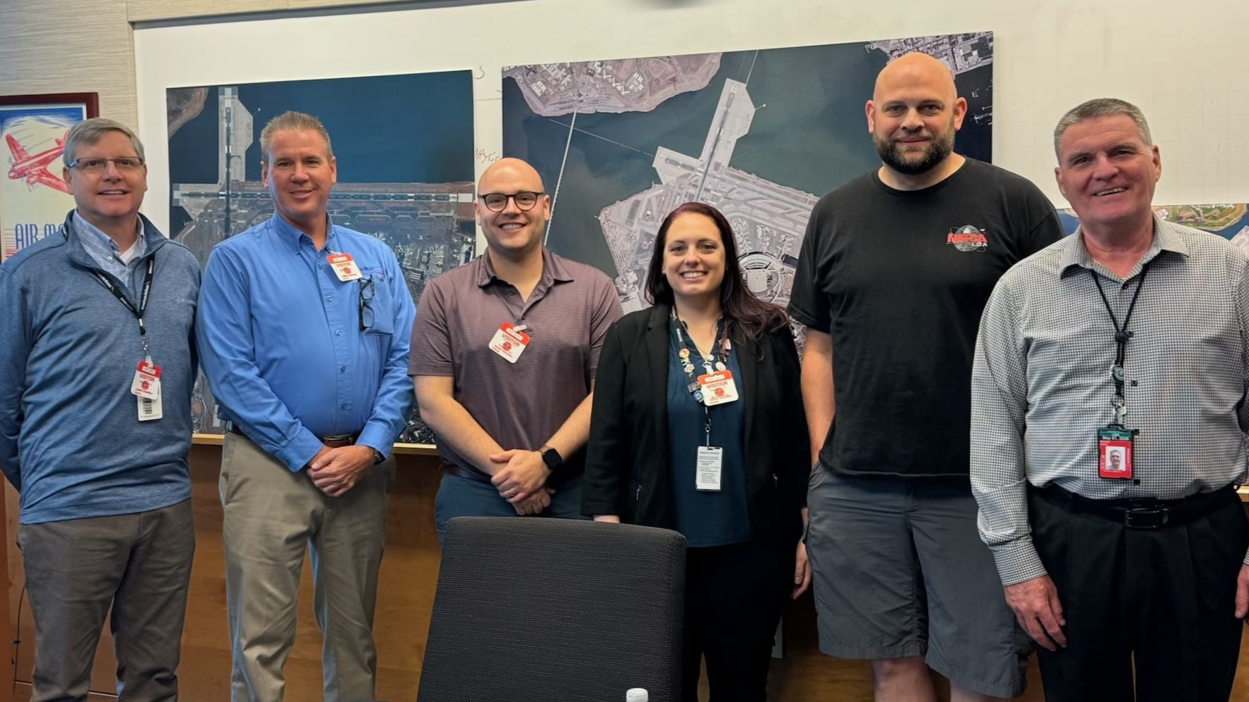 five men and one woman in a conference room