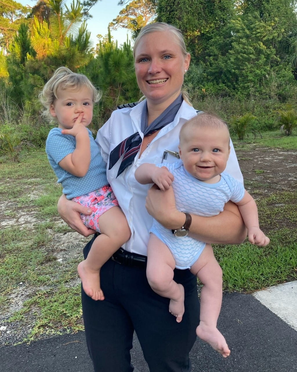 a female pilot holding two small children
