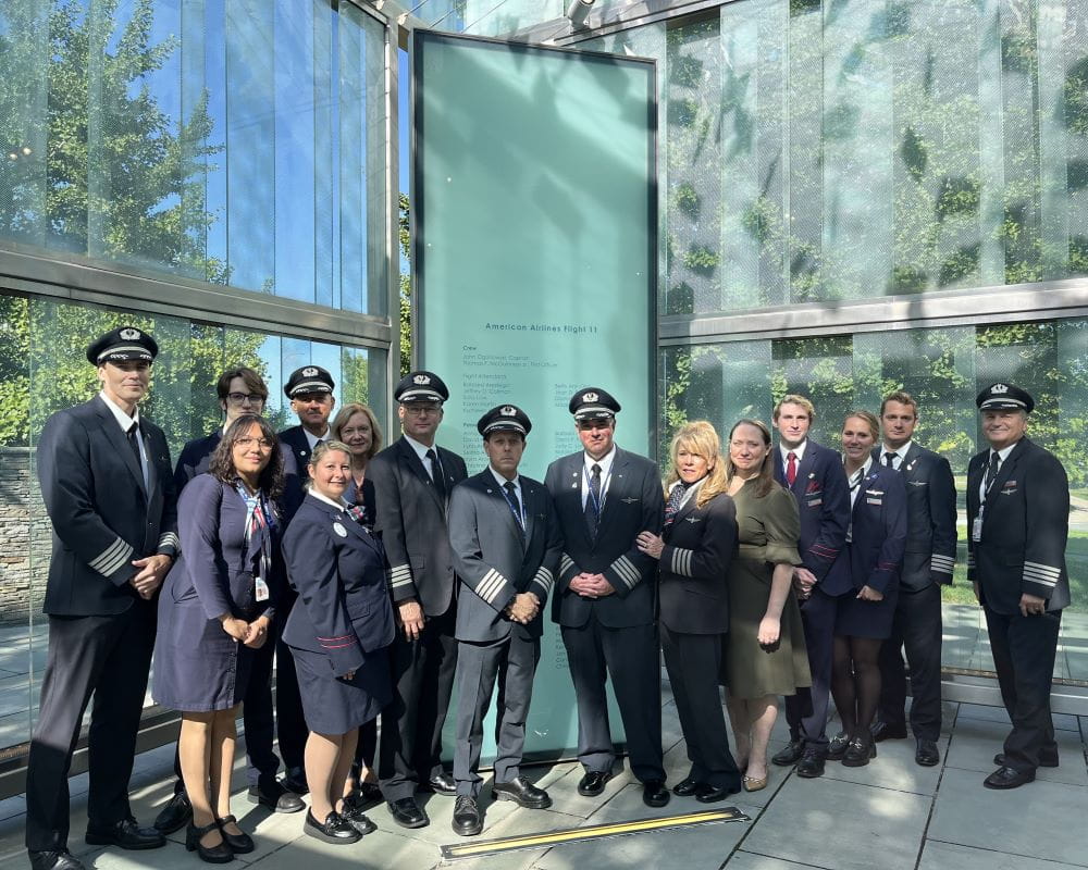 a group of pilots in front of the Flight 11 memorial at BOS
